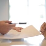 crop businessman giving contract to woman to sign